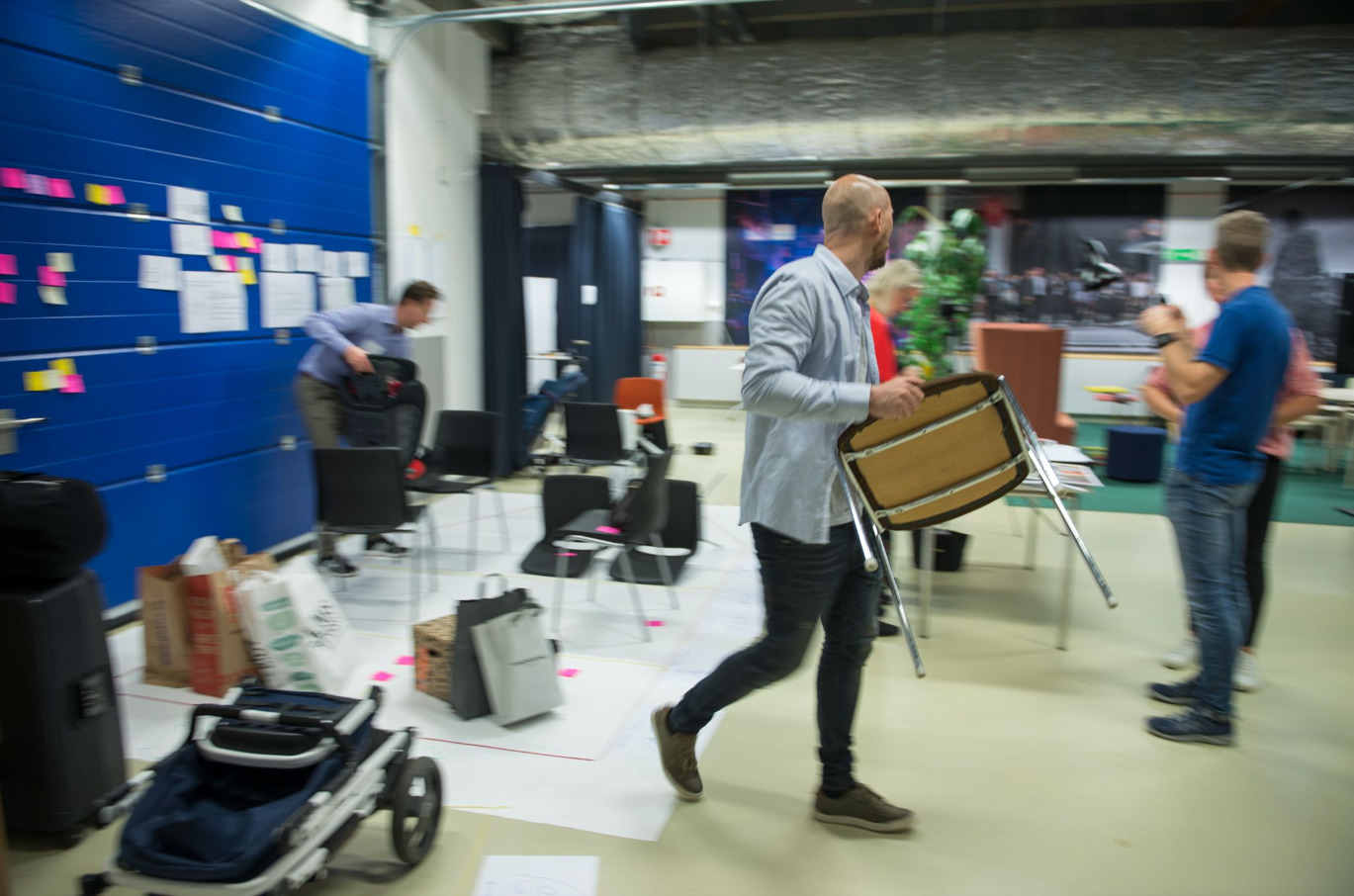 People organizing chairs and a walk with sticky notes.