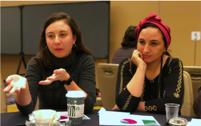 A couple of women sitting at a table AI-generated content may be incorrect.