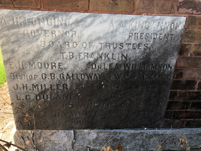 A stone plaque with writing on it Description automatically generated