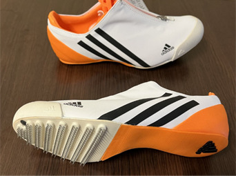 A pair of white and orange shoes AI-generated content may be incorrect.