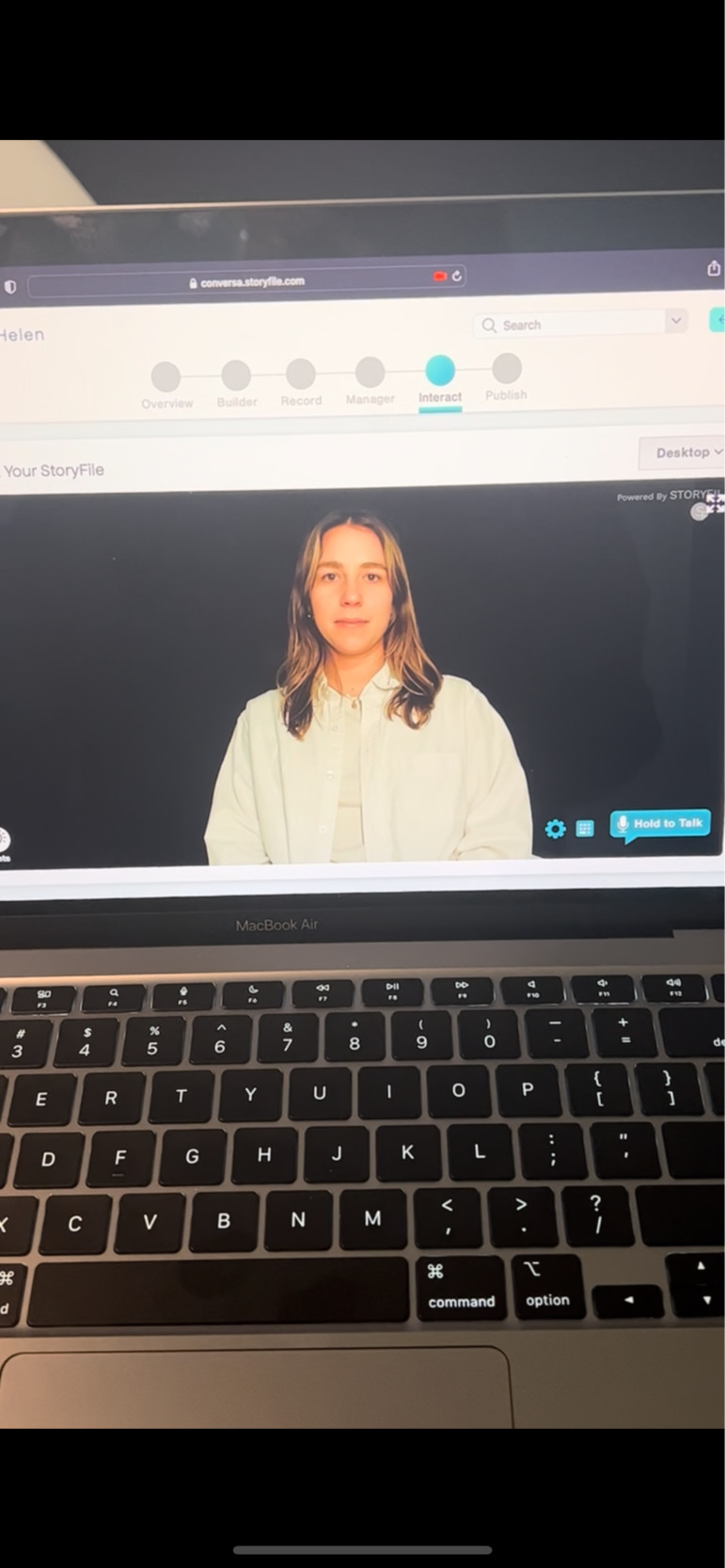 A computer screen with a woman appearing in front of a black backdrop