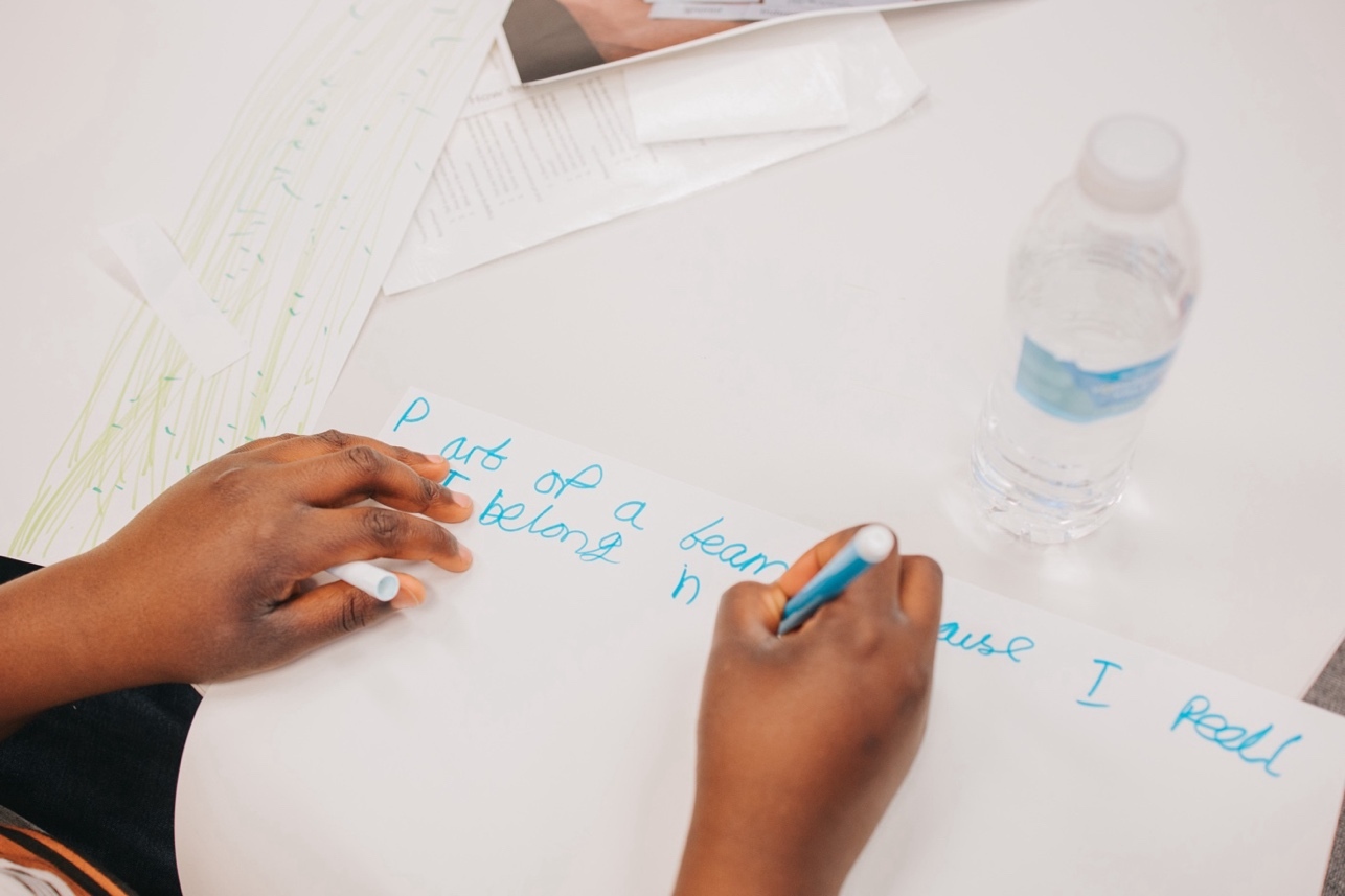 A person writing on a piece of paper Description automatically generated