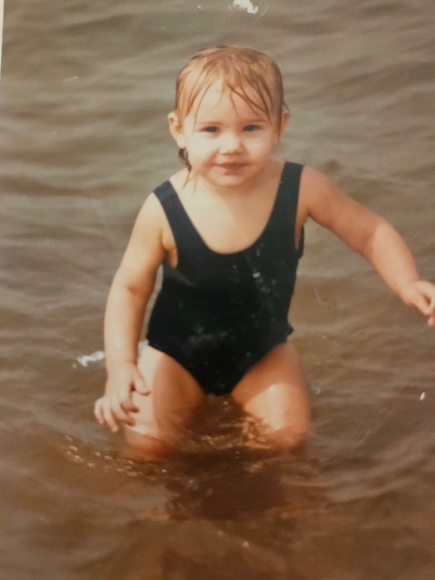 A child in a body of water Description automatically generated