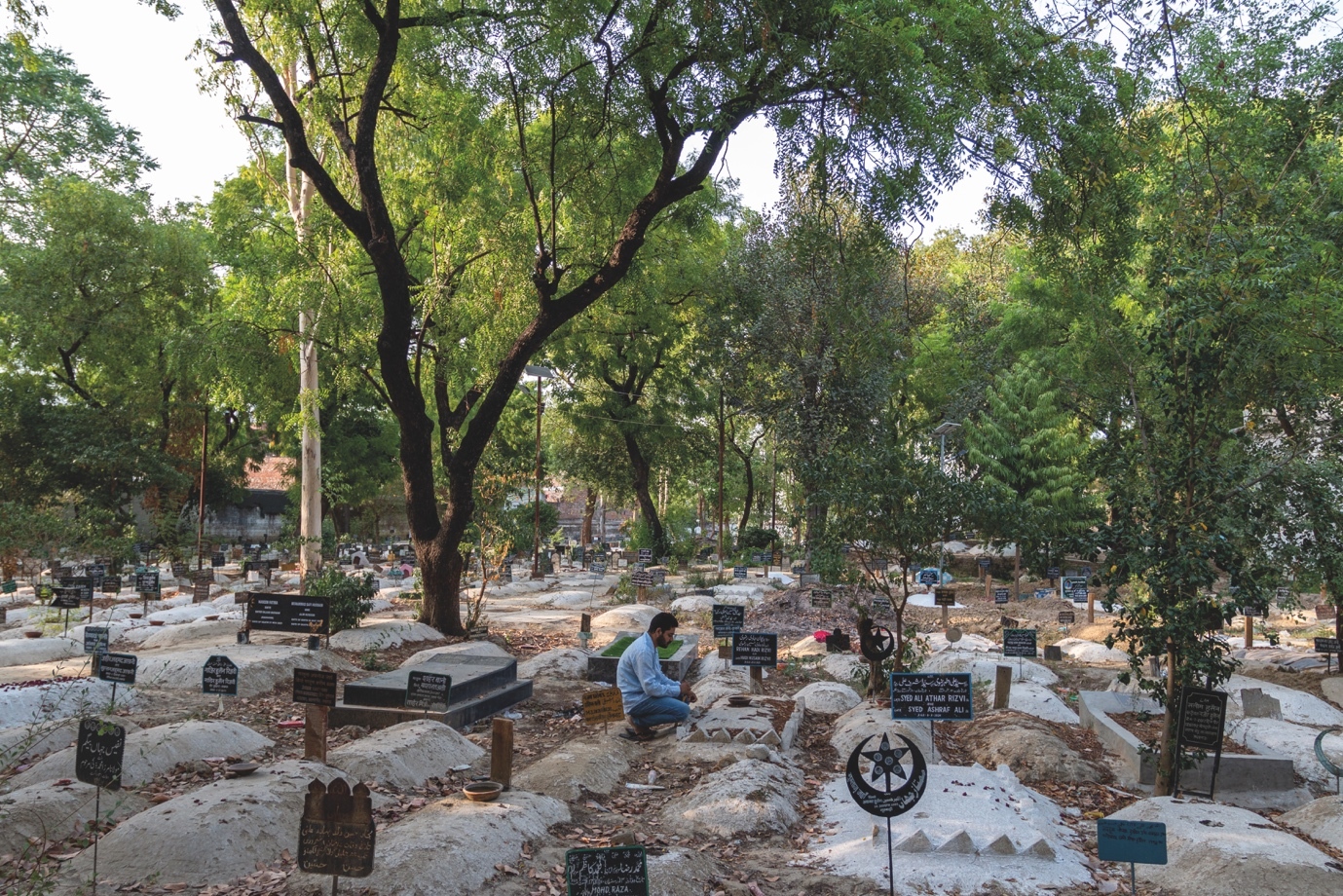 A person sitting in a cemetery Description automatically generated