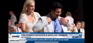 A person and person standing together Description automatically generated