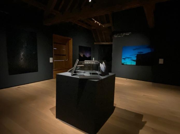 A room with a black table and a wood floor Description automatically generated