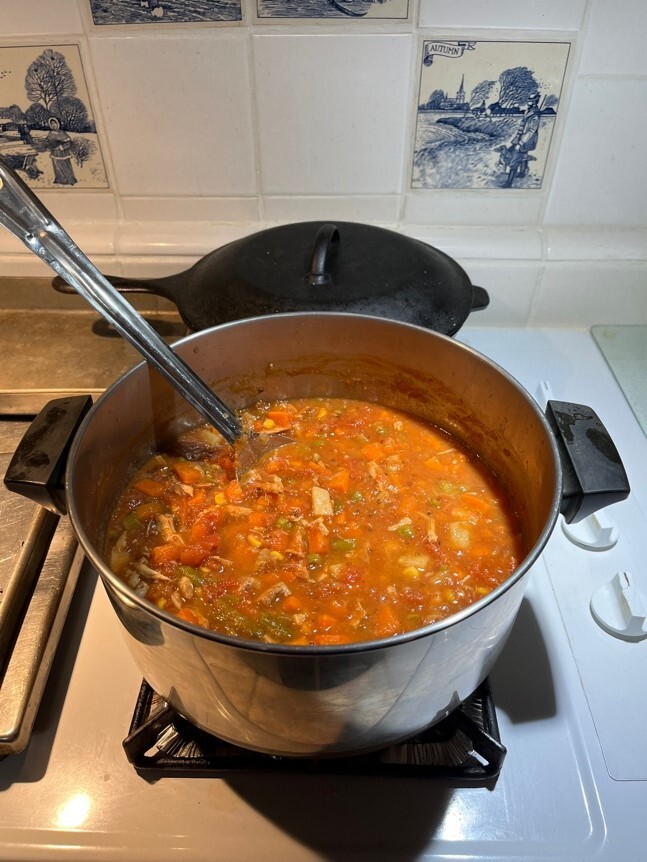 A pot of soup on a stove Description automatically generated