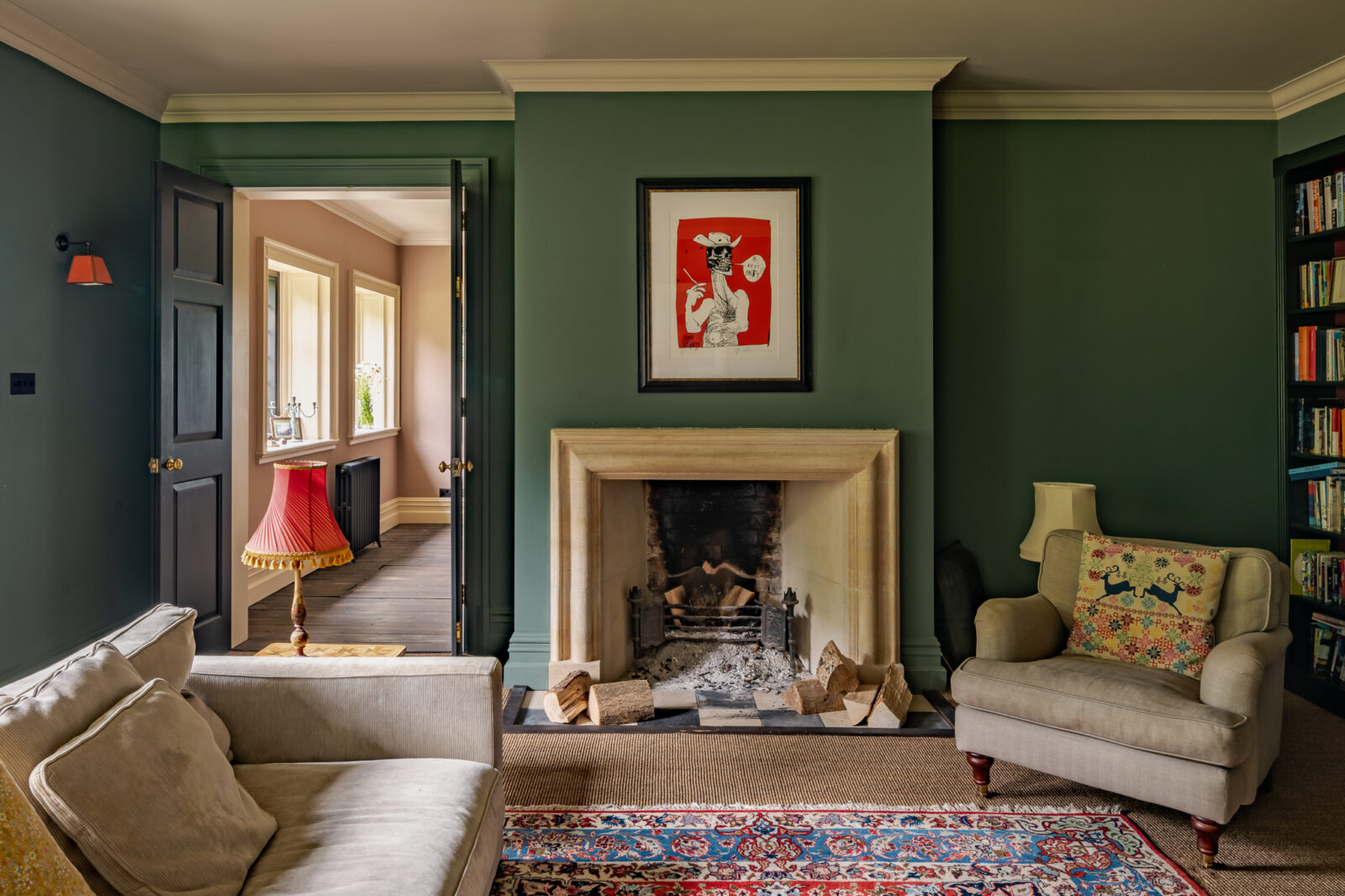 Deep green living room with fireplace, old furniture and patterned rug