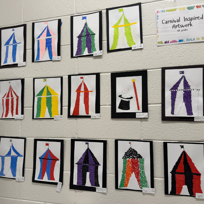 A wall display showcases colorful, dot-art circus tent artwork created by students.