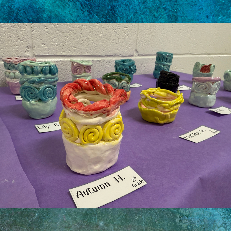 A display of colorful, handmade ceramic pots with decorative swirls and textured rims.