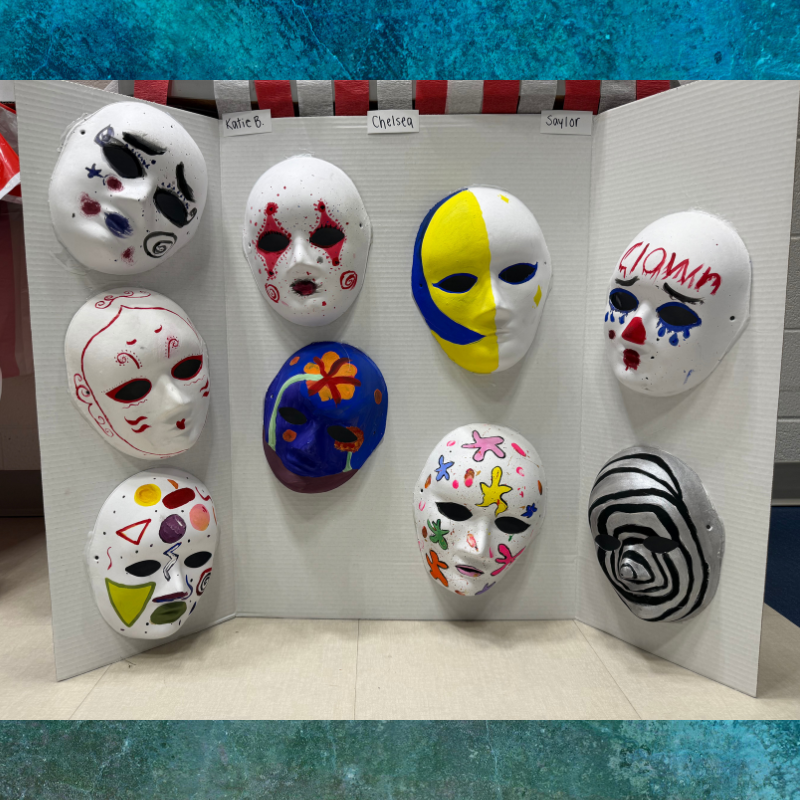 A display of nine colorful and uniquely decorated masks on a white tri-fold board.
