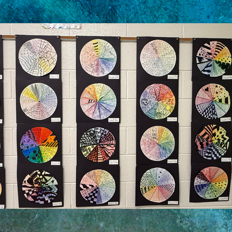 A wall display of circular art pieces, each divided into segments filled with intricate patterns and colors.