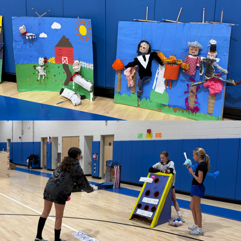 Children's handmade puppets and backdrops are displayed in a gymnasium.
