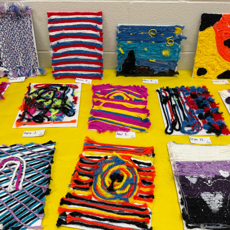 A display of colorful woven art pieces created with yarn, featuring various patterns and designs.