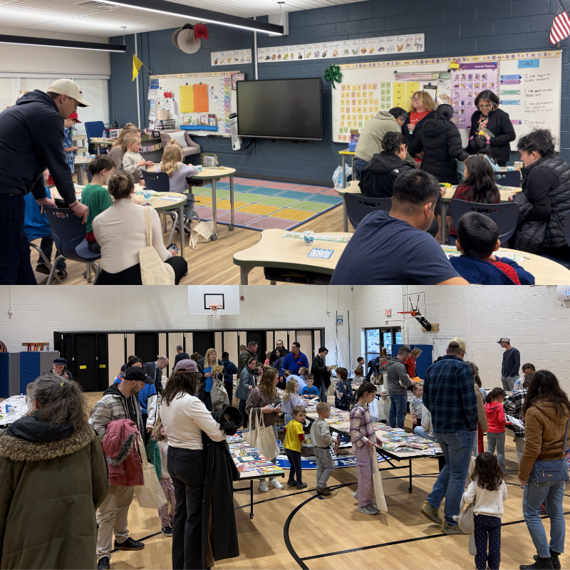 A classroom scene with children and adults gathered around desks, with a large screen at the front.