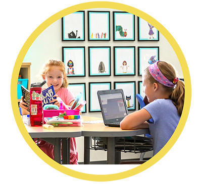 Photo of a kid reading and a kid playing on a laptop