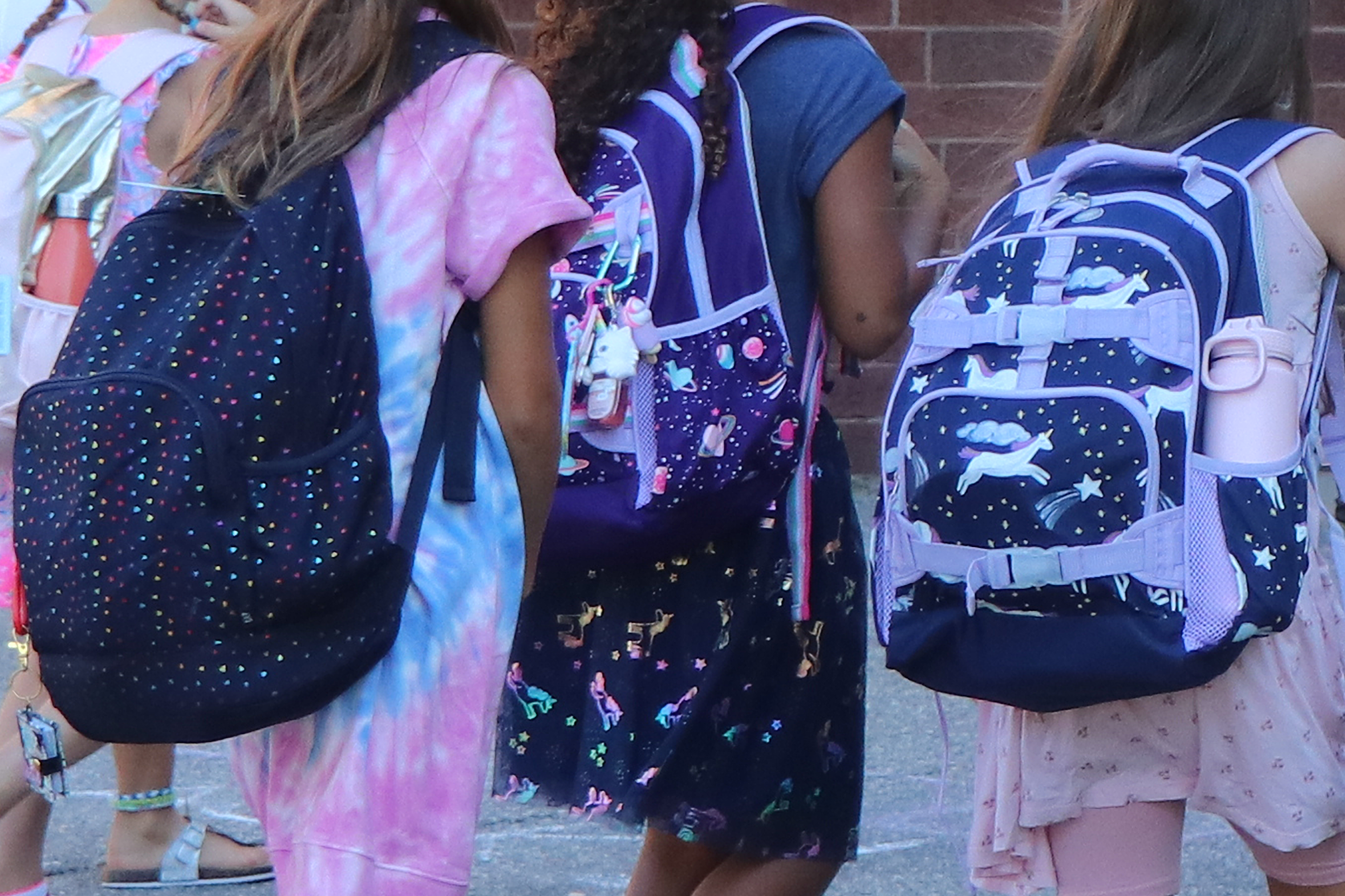 Students outside school with backpacks