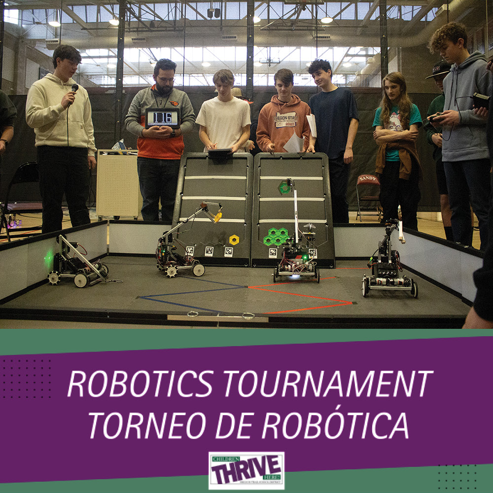 Students and teacher around the competition field where robots stack disks to score points.
