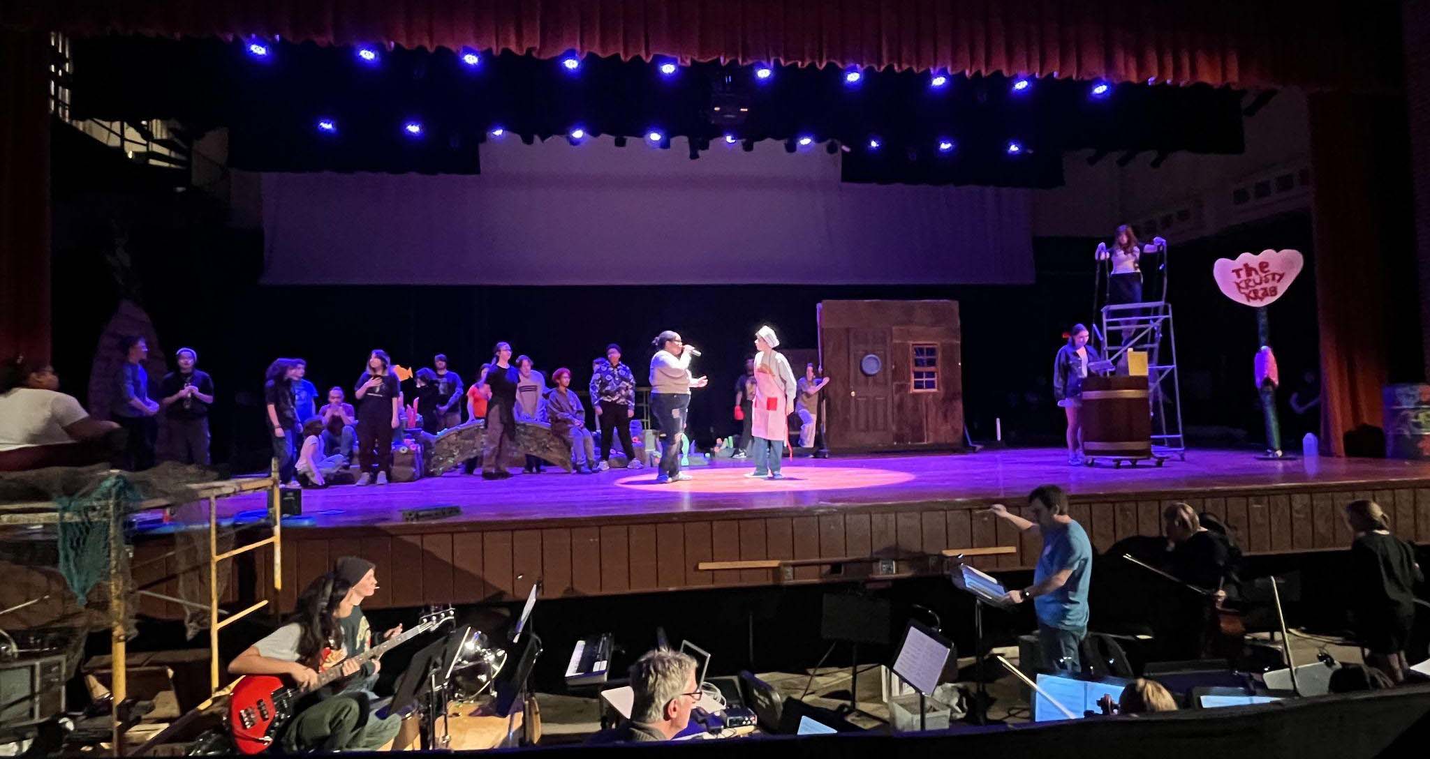 students on stage and in the pit at SpongeBob rehearsal