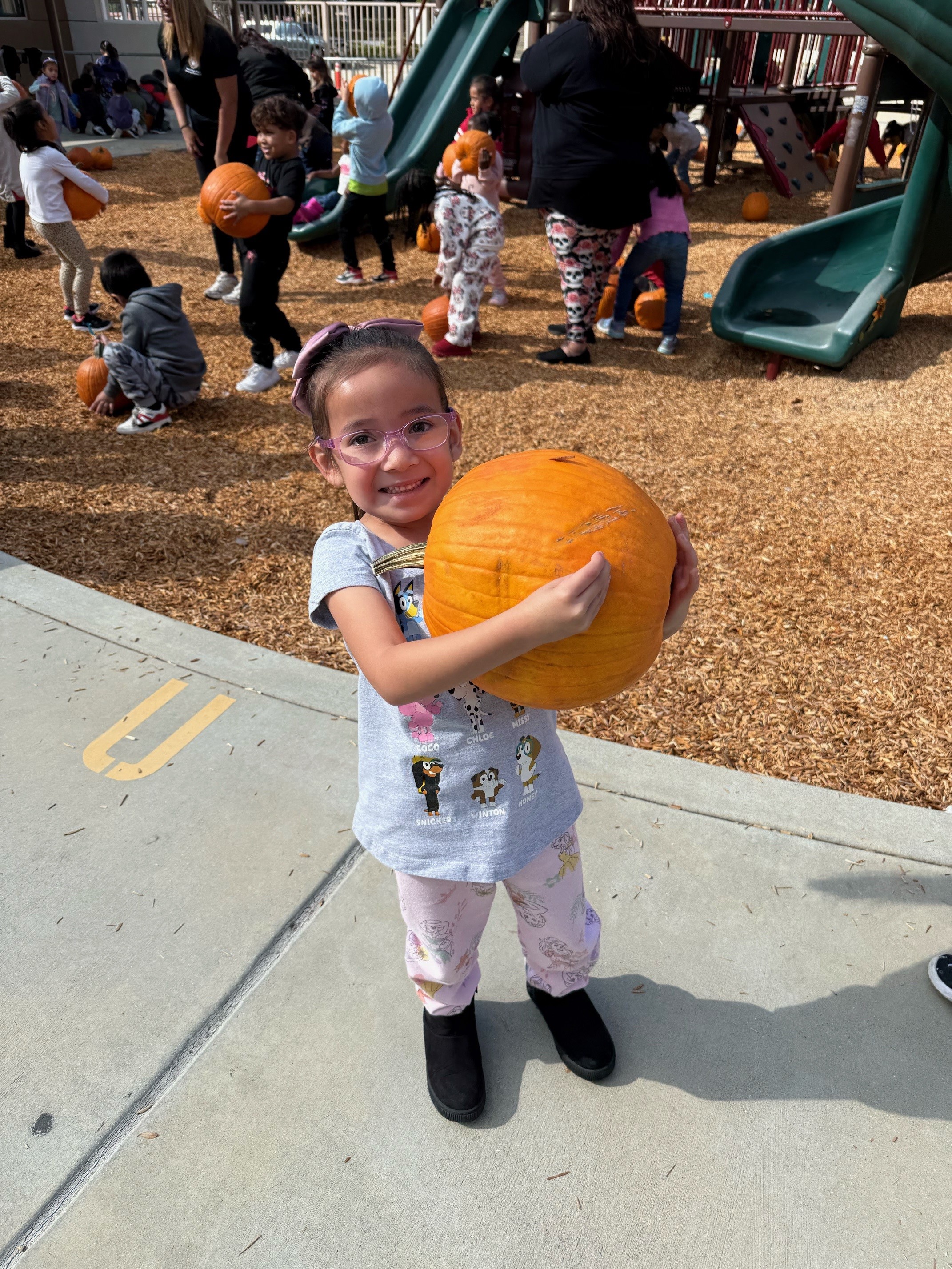 Image of Kinder student girl holding a pumpkin