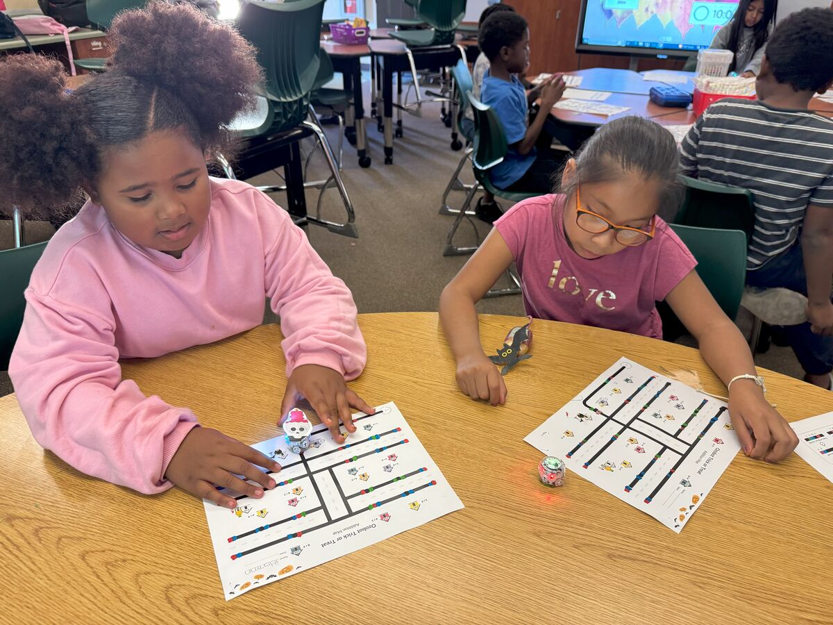 Image of two students working on on Sphero Bolt and Ozobots project.