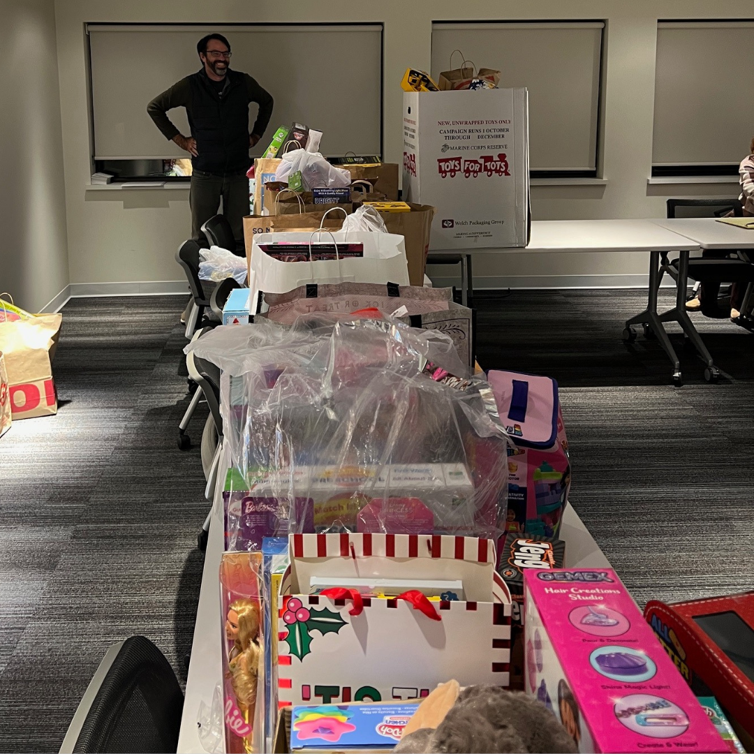 a representative smiling at a table full of toys