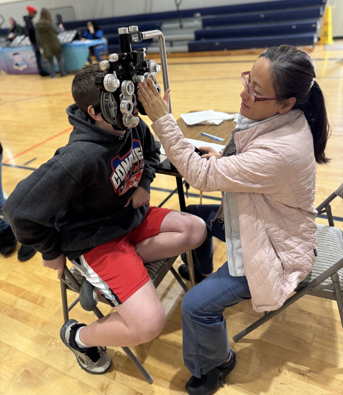 boy getting eye exam with lady