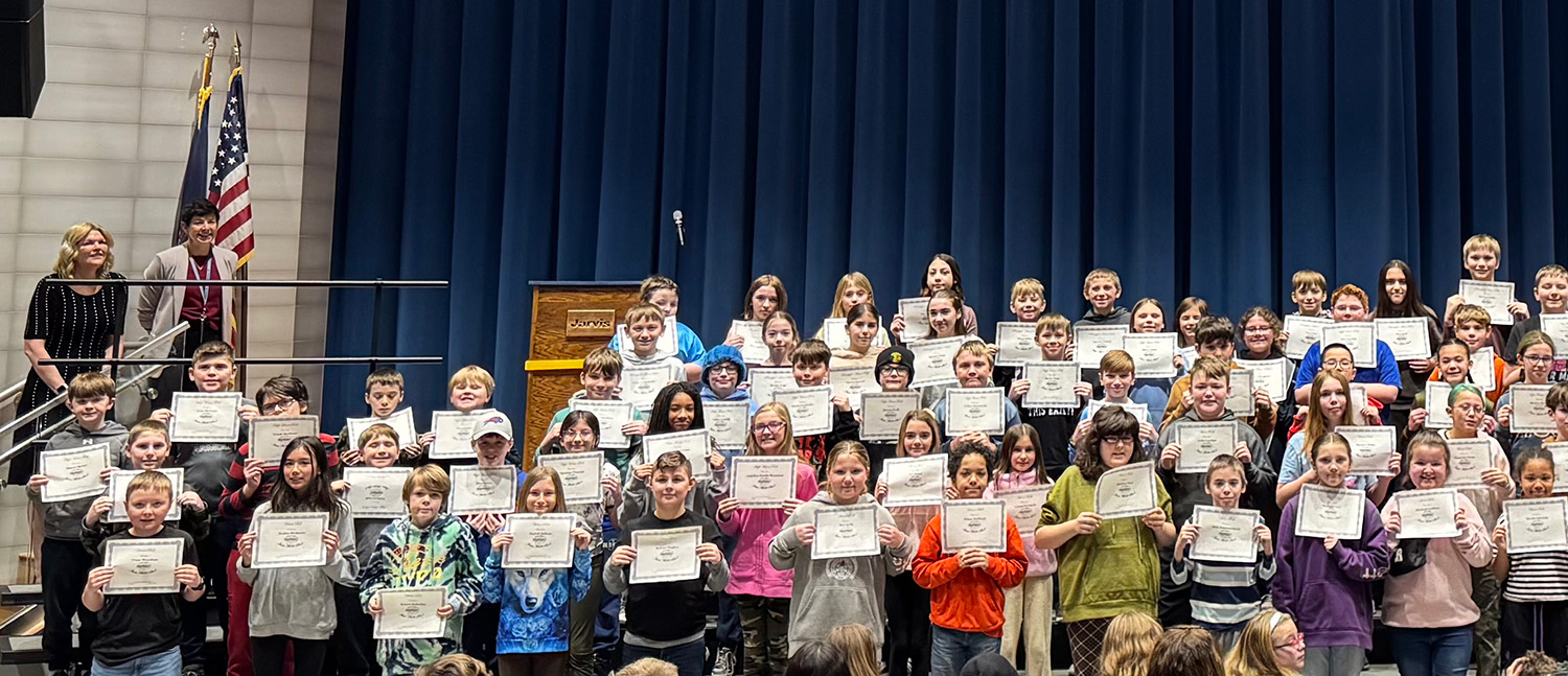 group of students on stage holding certificates