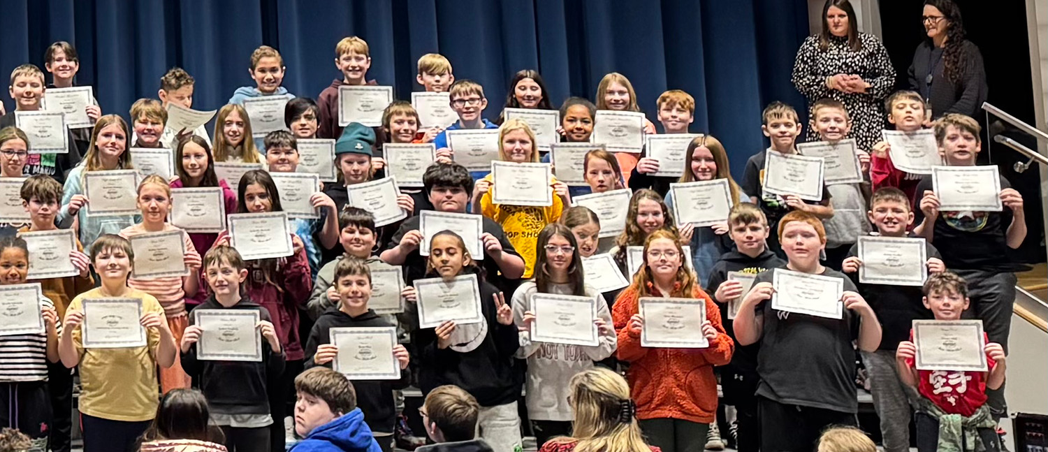 group of students on stage holding certificates