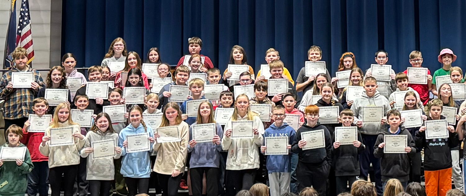 group of students on stage holding certificates