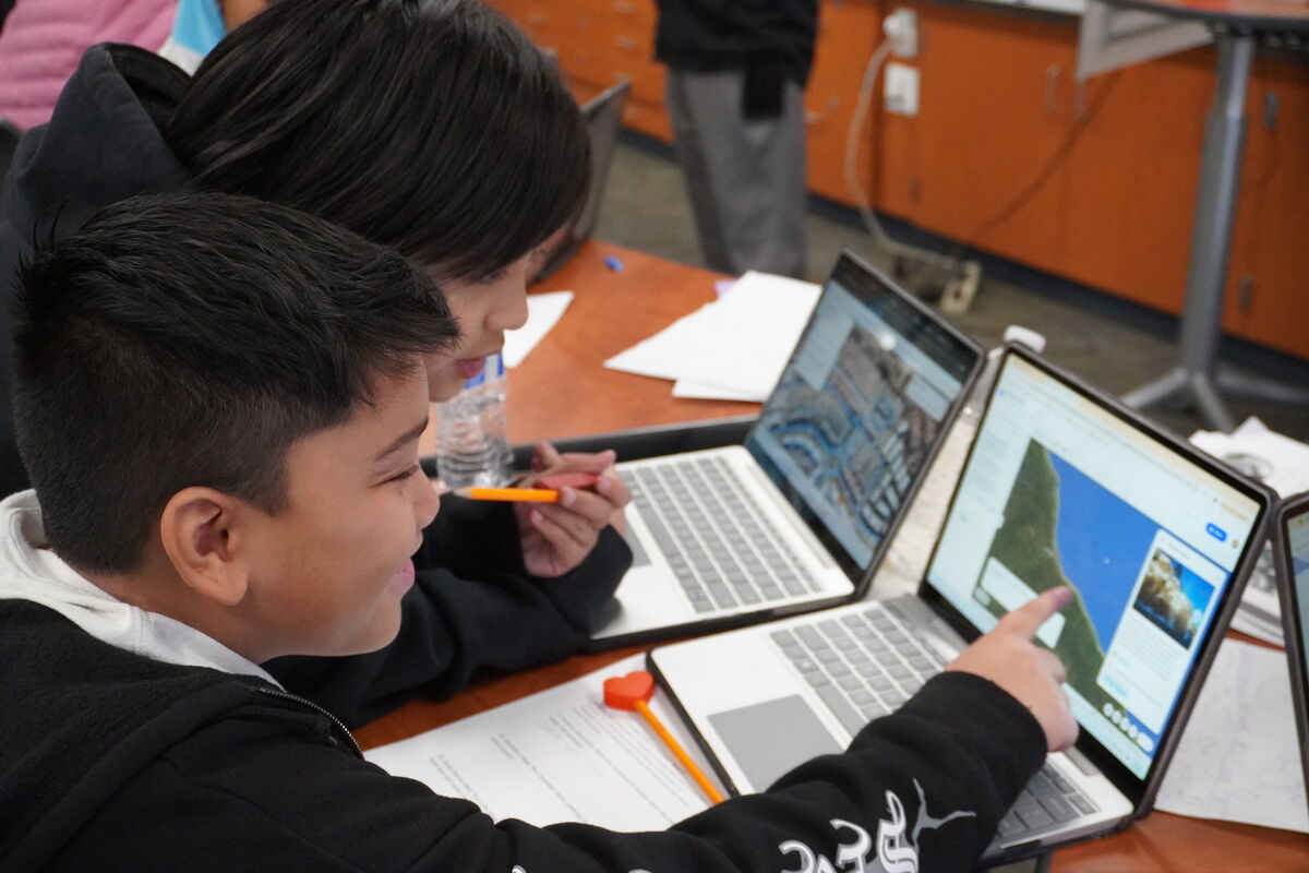 Image of 5th-grade students actively engaging  in classwork on their technology devices, enhancing their learning experience through interactive, hands-on activities.