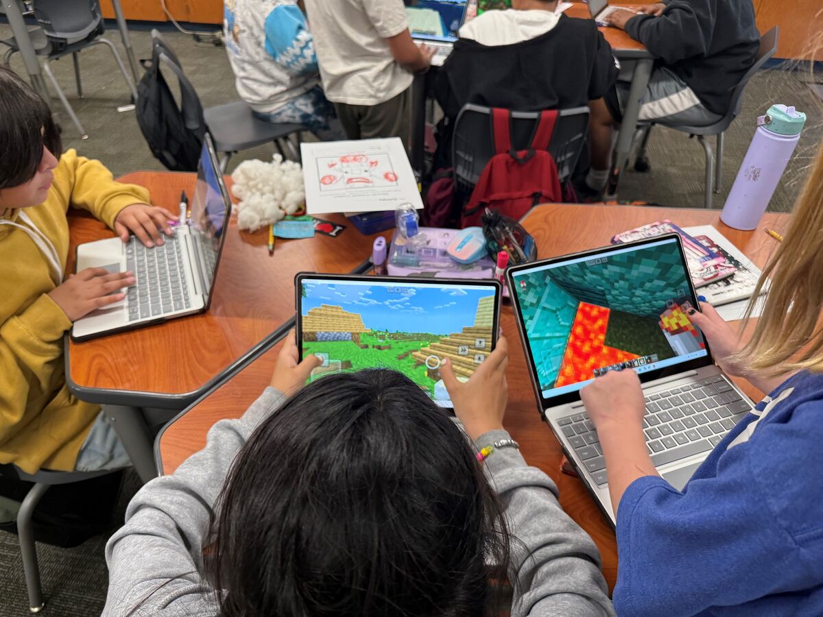 An image of 5th-grade students actively engaging with Minecraft for Education on their technology devices, enhancing their learning experience through interactive, hands-on activities.