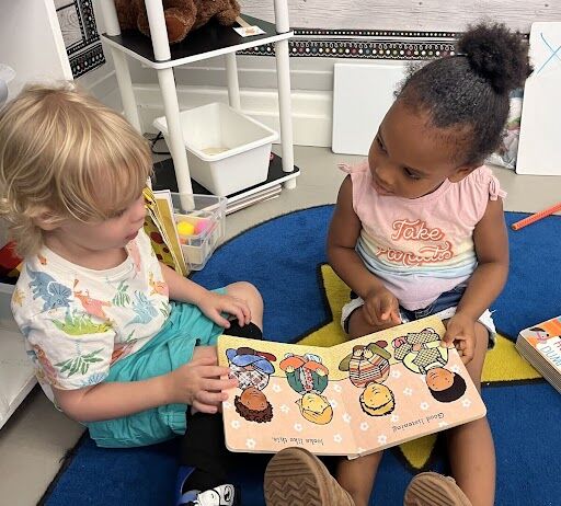 two preK students reading a book
