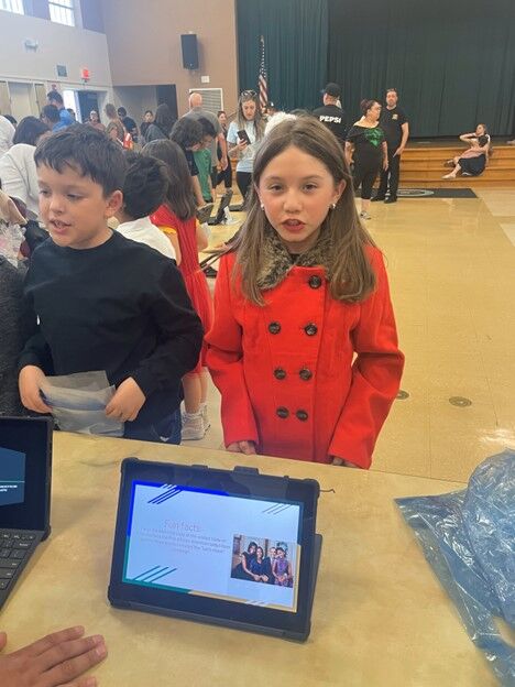 Image of a CES 3rd Grade Student presenting her project display.