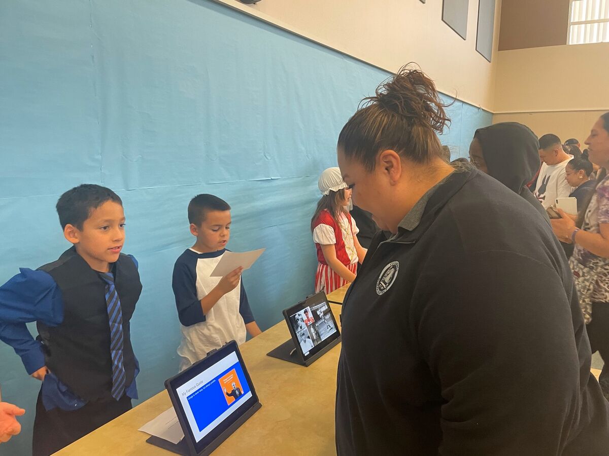 Image of a CES 3rd Grade Student presenting her project display with Board Member Ramirez.