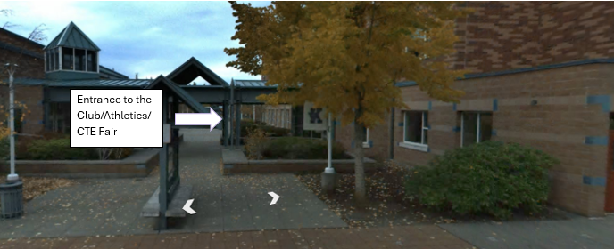 A sign pointing towards the entrance of a school building, indicating the location of a club/athletics/CTE fair.