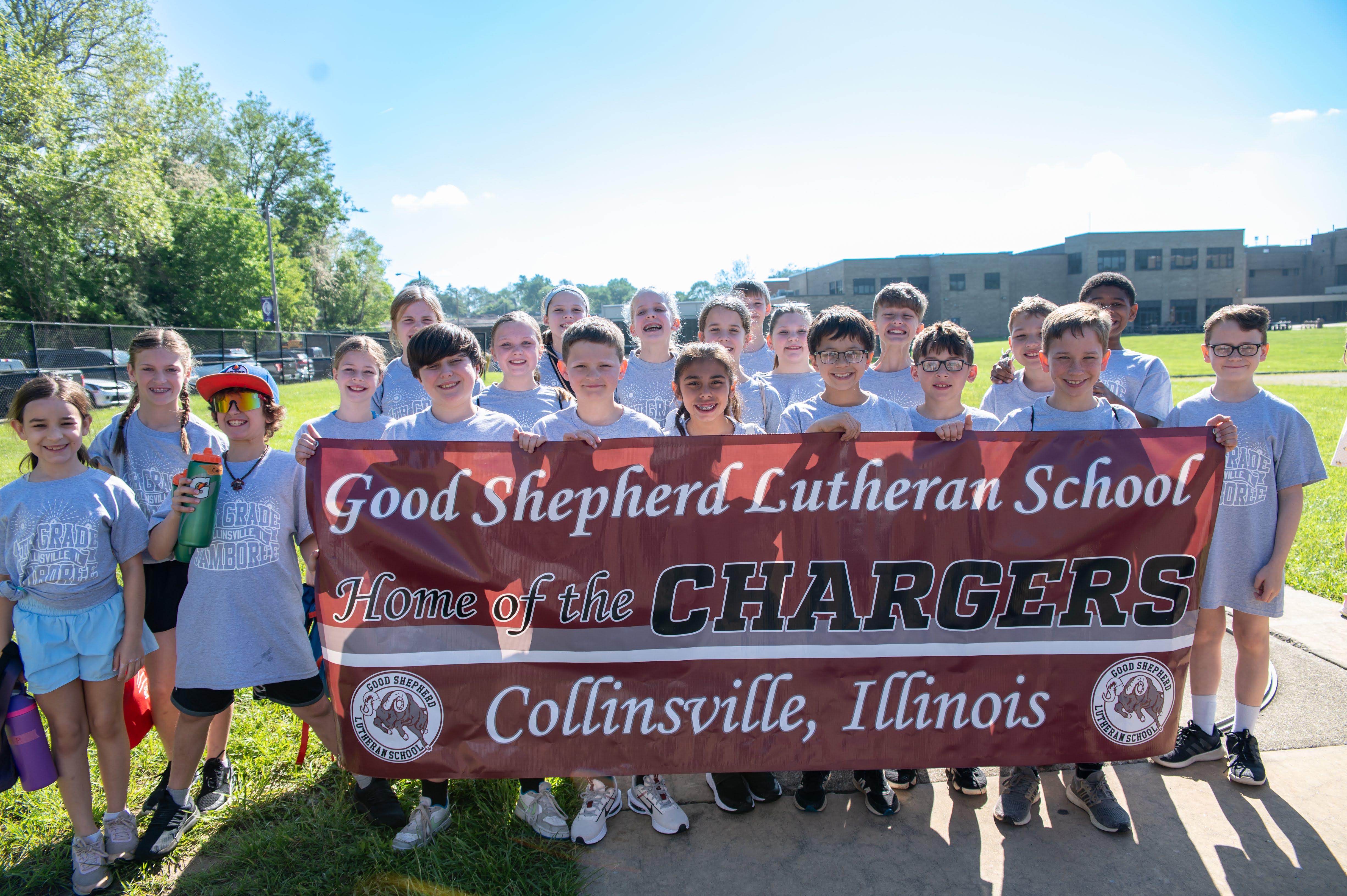 A group of students from Good Shepherd Lutheran School in Collinsville, Illinois, pose with a banner that reads 'Home of the CHARGERS'.
