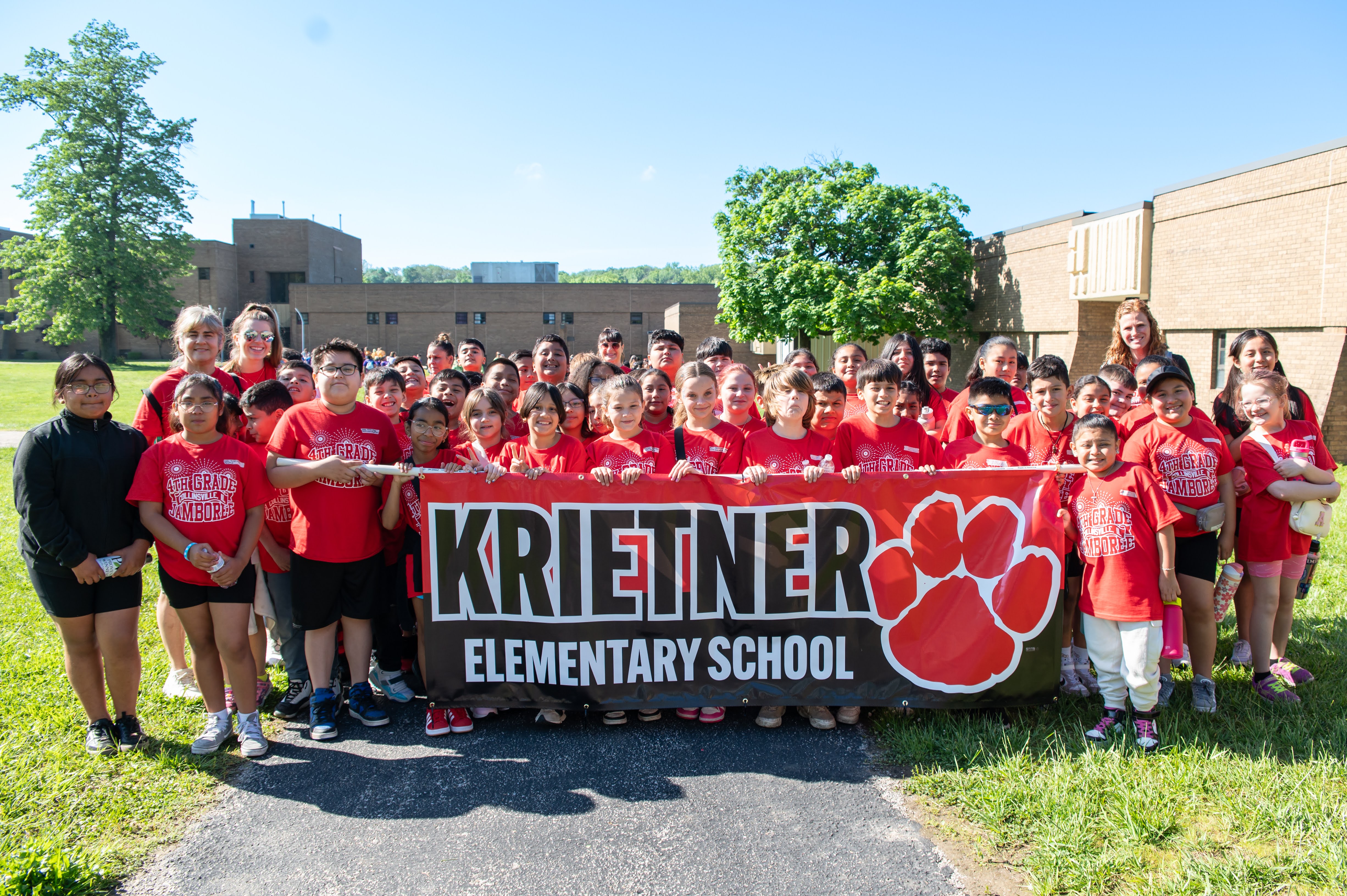 A group of students from Krietner Elementary School pose for a photo with a banner.