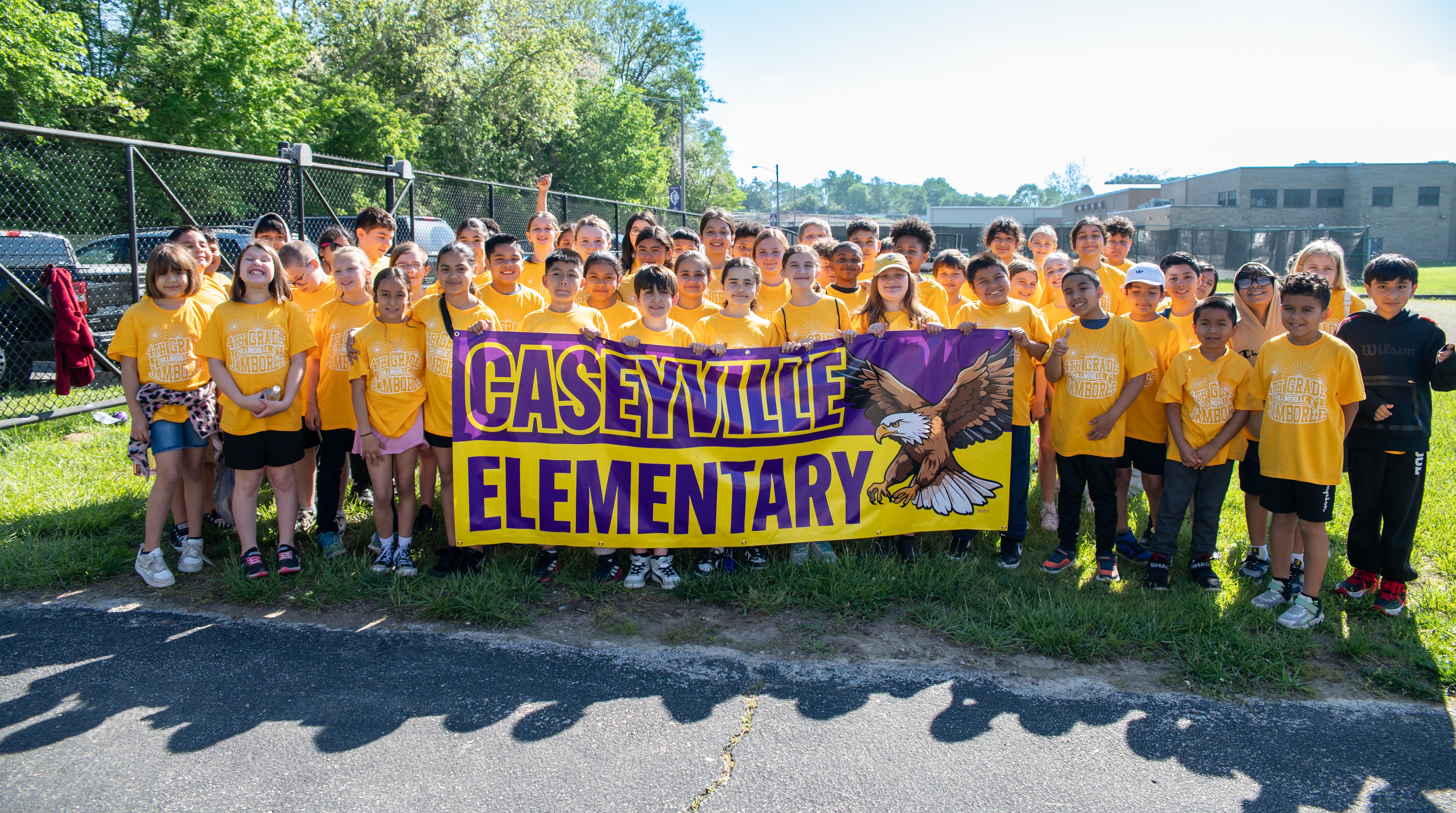 A group of students from Caseyville Elementary School pose for a photo, holding a banner with the school's name and a bald eagle.