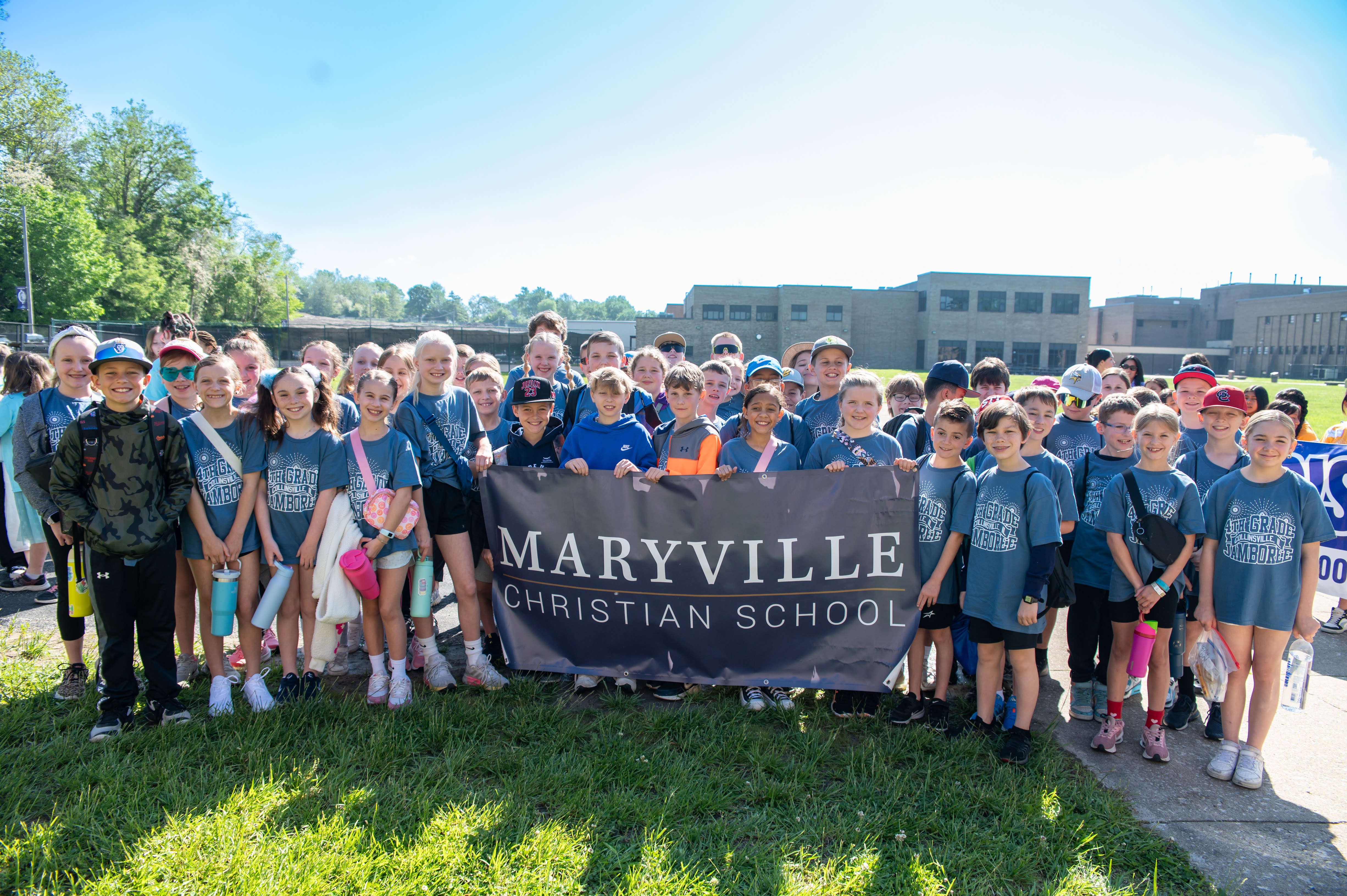 A group of students from Maryville Christian School stand together holding a banner.