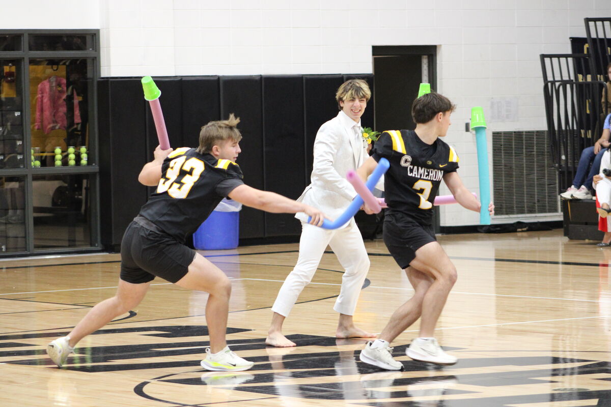 Students play a fun game with pool noodles and plastic cups