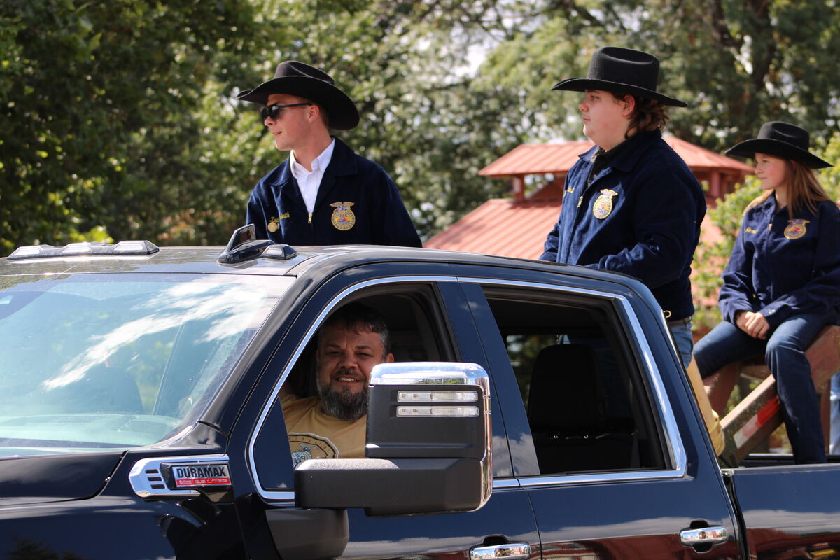 FFA members stand in a black truck, smiling.