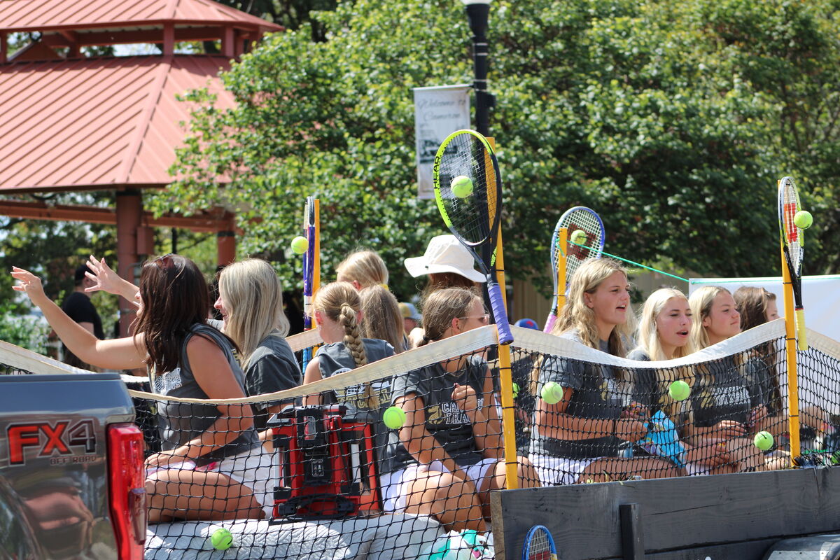 Tennis team on a float with a net and tennis balls and rackets