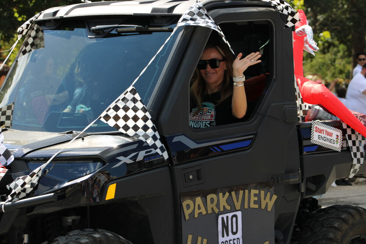 Parkview administrators wave from a black side-by-side on the Parkview parade float