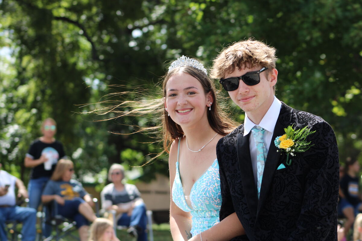 Senior queen candidate in light blue dress and her king candidate smile