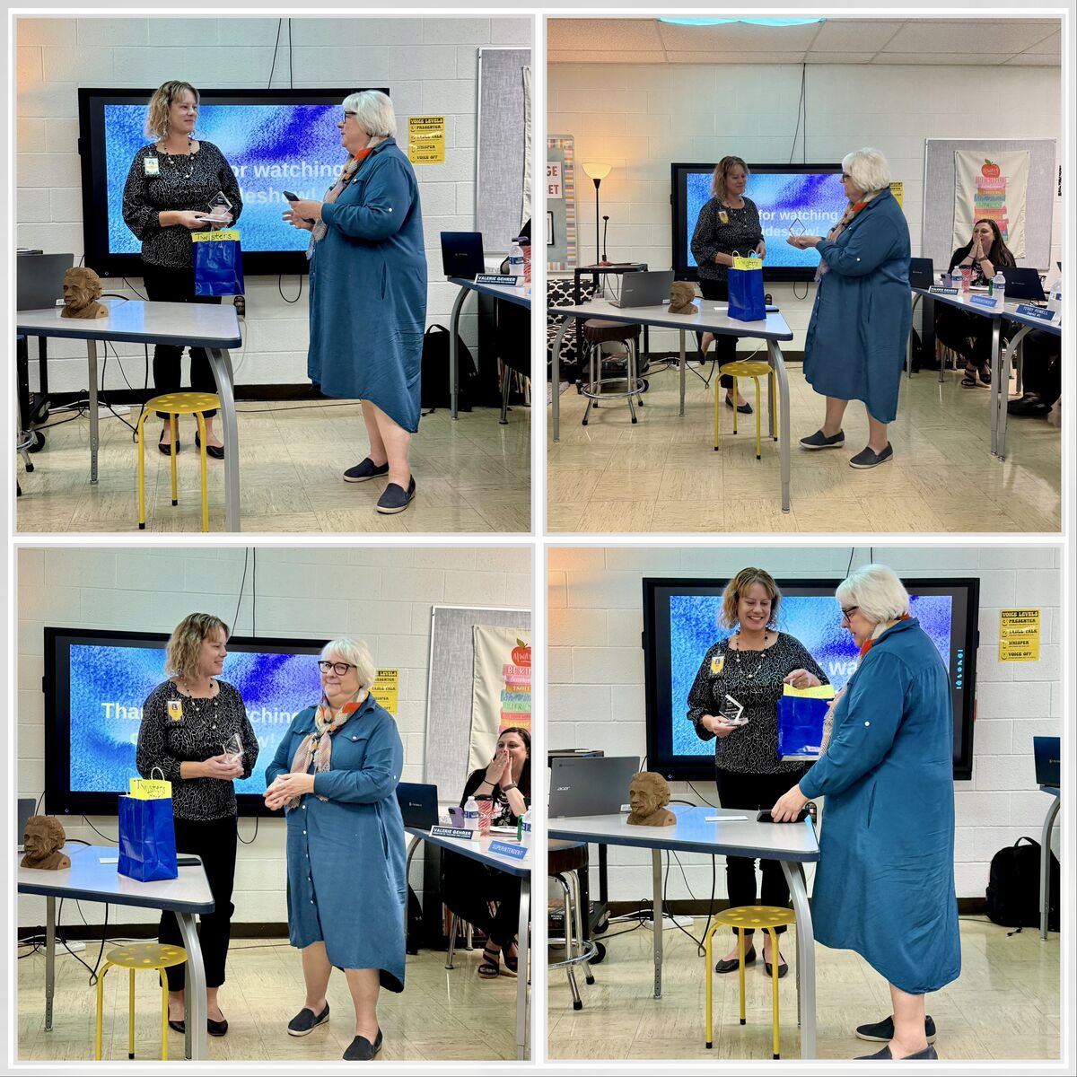 Two women stand in a classroom, one presenting an award. A screen displays text.