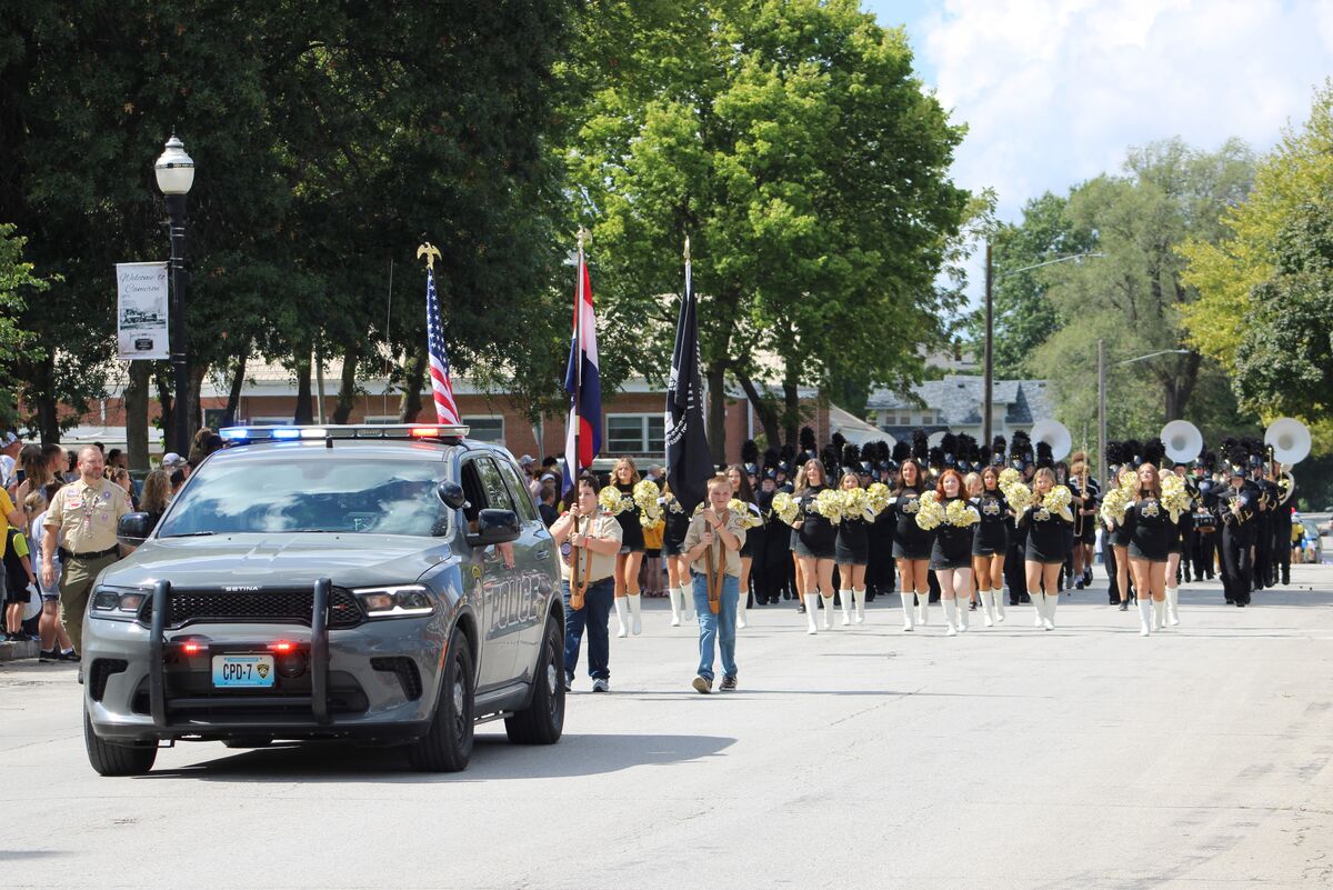 Law Enforcement vehicle leads scouts, dance team, band, and color guard in a parade