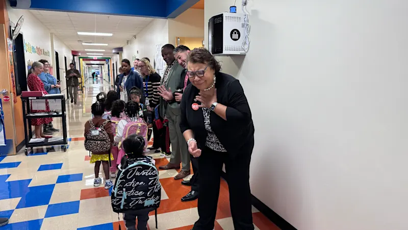 NEA VP smiles as students walk to class