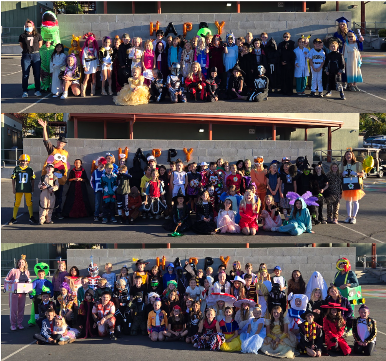 A large group of children and adults in Halloween costumes pose for a photo.