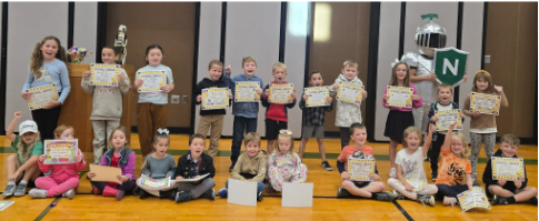 A group of children hold certificates, smiling for the camera.